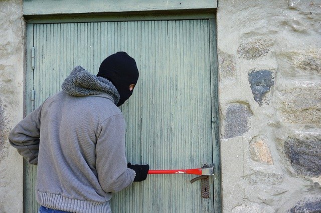 voleur forçant la porte avec des outils