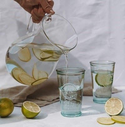 rellenando vasos con jarra de agua con limón