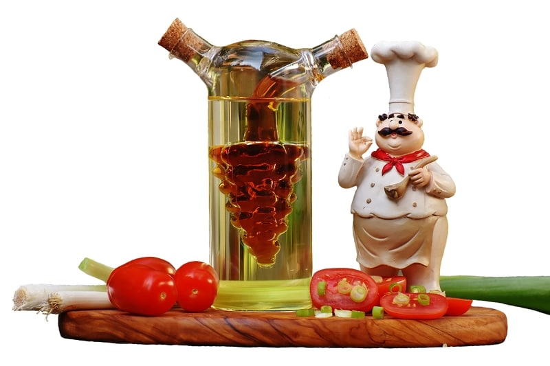 recipiente con vinagre junto a figura de cocinero y tomates